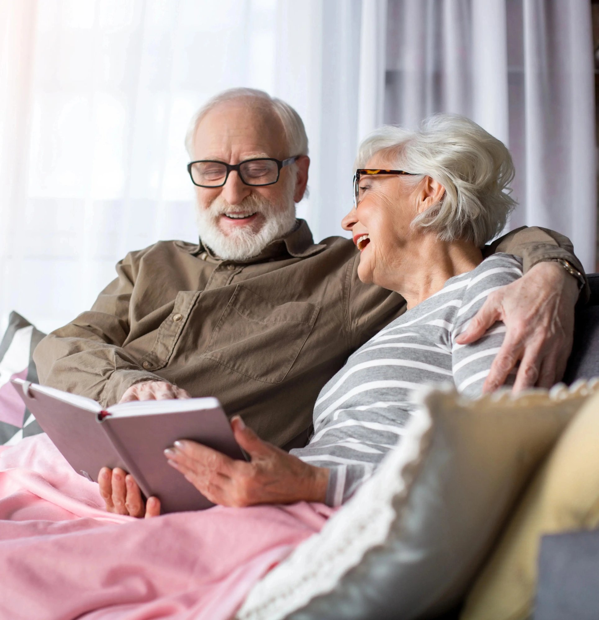 Man and woman on the couch reading a book