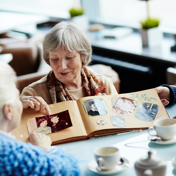 Older woman reviewing a scrapbook.